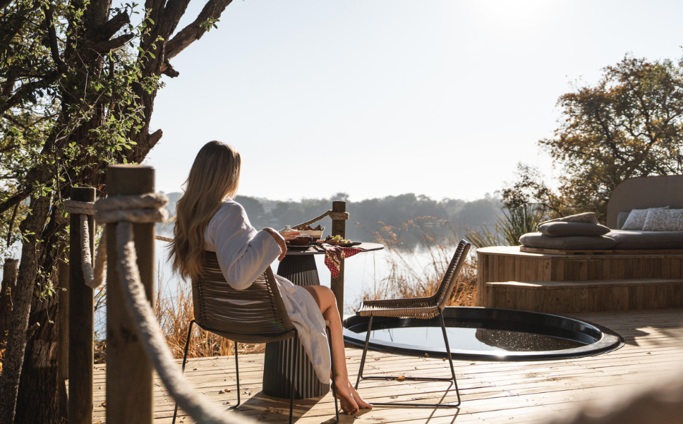Guest enjoys the view of the Zambezi River from their private deck at Victoria Falls River Lodge.